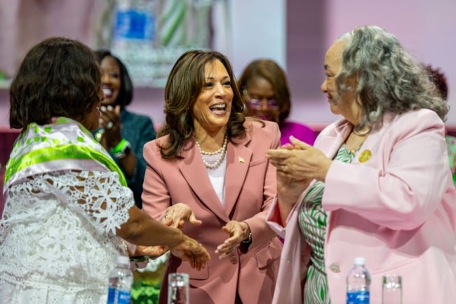 Kamala Harris, wearing a pink suit, smiles and shakes hands at this year's Alpha Kappa Alpha Boulé.