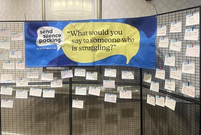 A three-panel display with a blue sign that reads "Send silence packing, 'What would you say to someone who is struggling?'" 