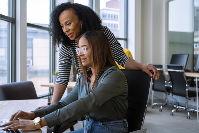 Older worker helping younger worker