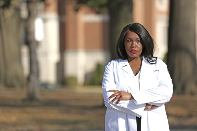 A photograph of Kimberly Diei in a white coat. 