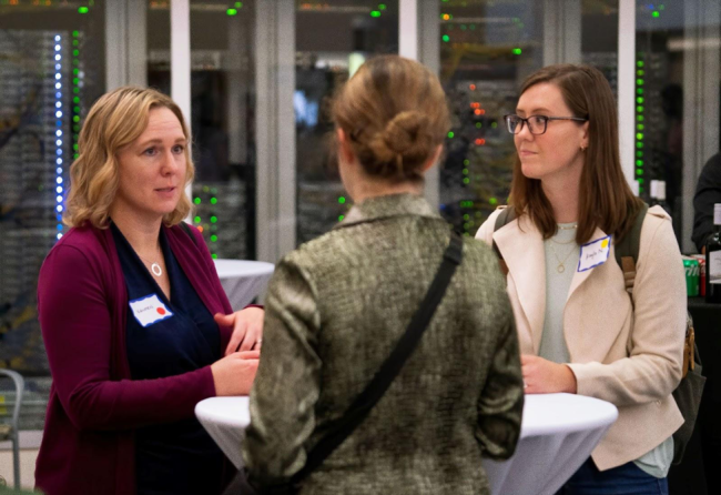 A Scripps Research alumna networking with two trainees