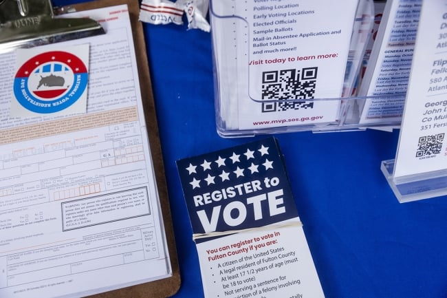 Voter registration materials sit on a blue tabletop