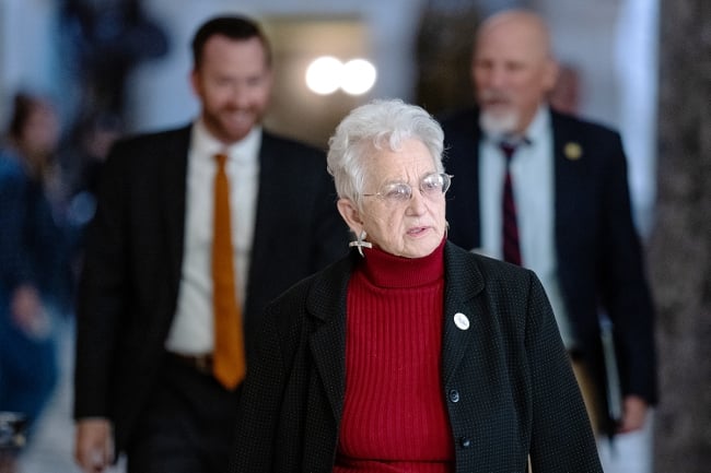 Virginia Foxx, a white woman with short white hair, walks down a hallway