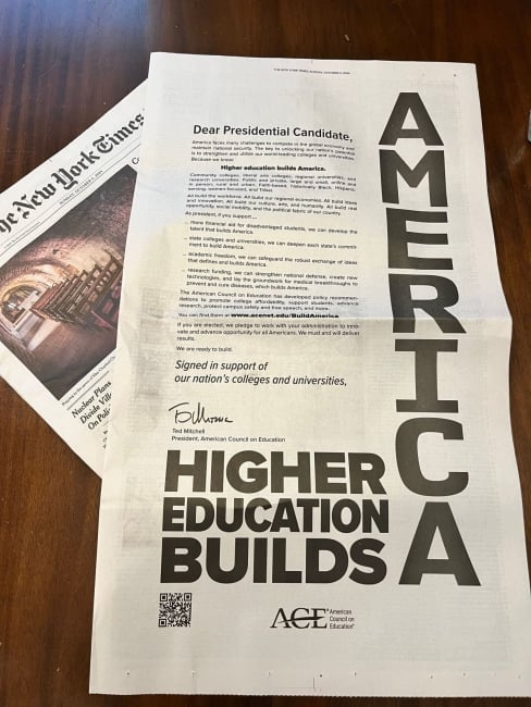 An open New York Times page reads in bold capital letters, "higher education builds America."