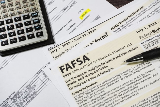 Close-up of federal financial aid application with calculator and tuition statement