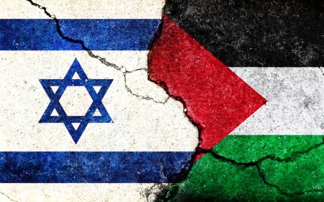 A photo illustration of two flags, one of Israel and the other of Palestine, colliding with each other with a crack going through both of them.