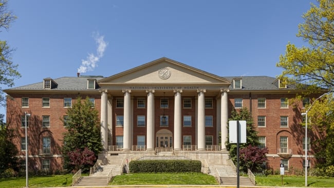  Bethesda Campus of the National Institutes of Health with the main historical building (Building 1) at the focus. It is a sunny spring day.