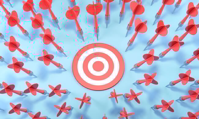 An image of dozens of red darts having missed the target.
