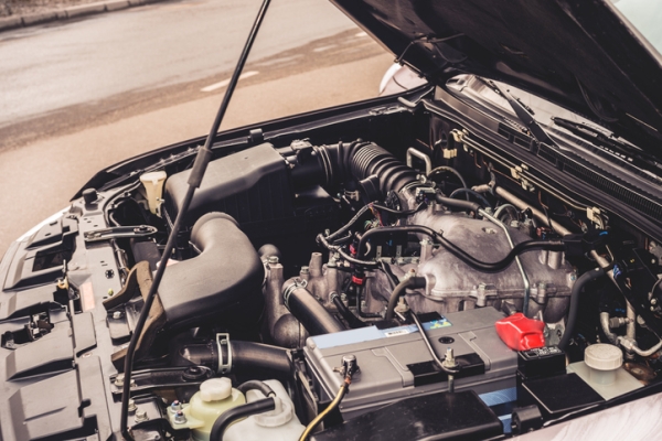 A close-up of the engine under the hood of a car. 